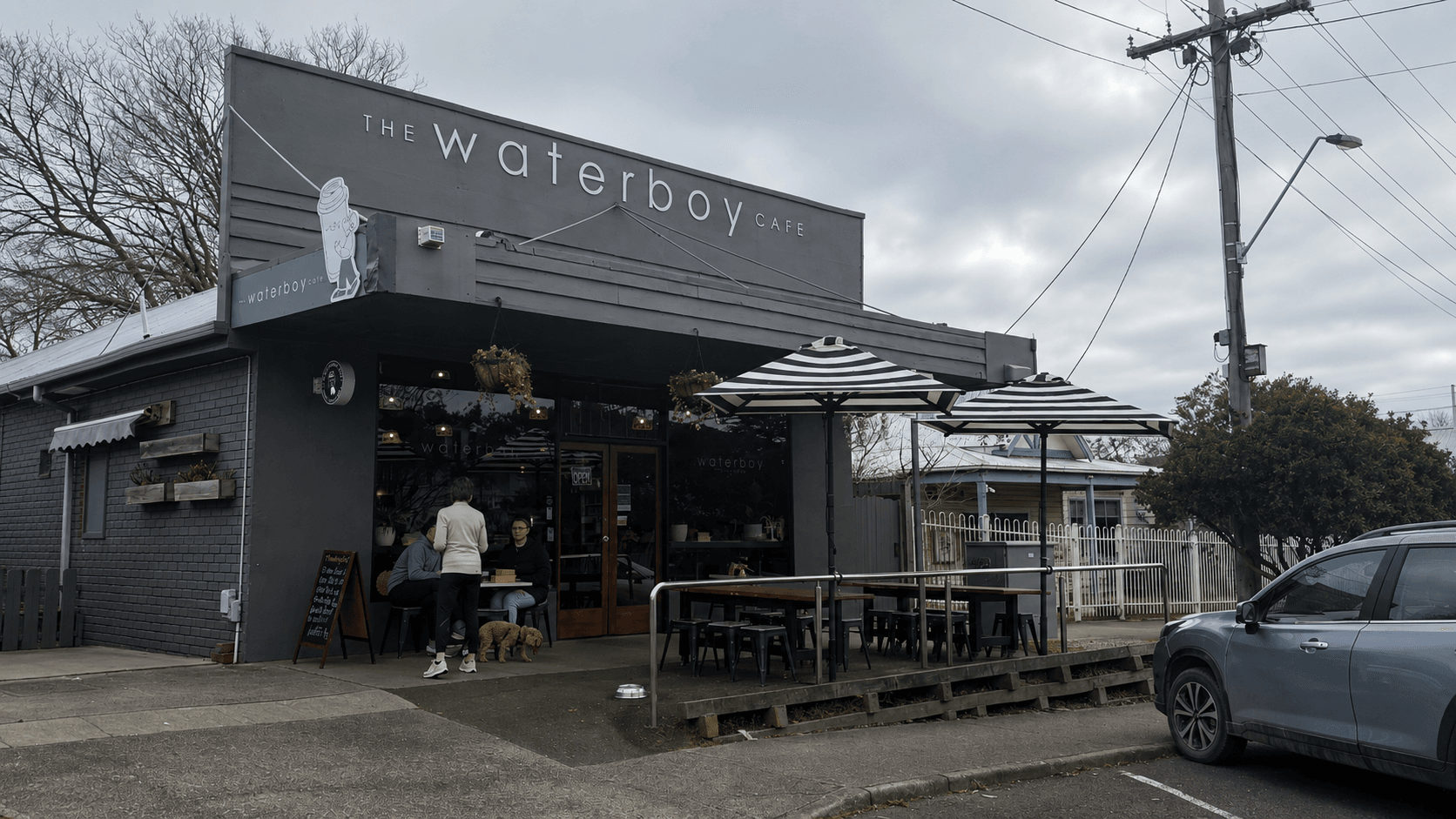 The Waterboy Cafe's shopfront on Chapel Street, Cowes, with the cafe's name lettered across the awning and the doors open to the street